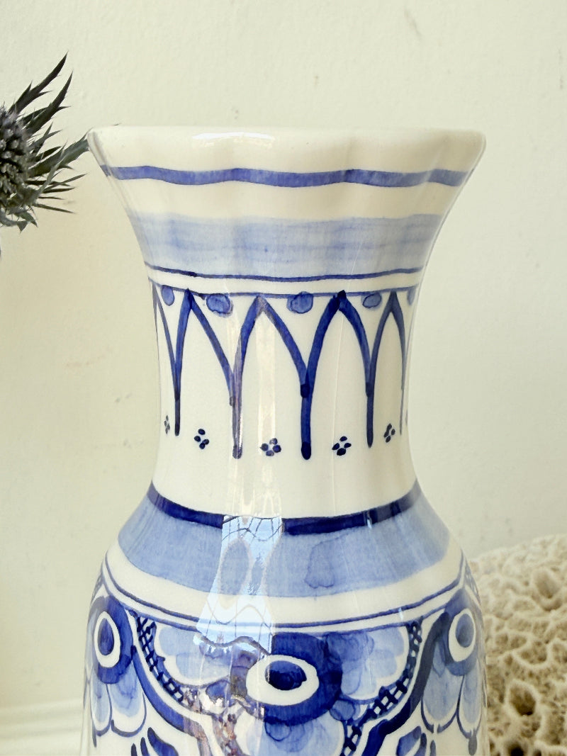 Vintage Delft style blue and white pottery vase with hand painted floral decoration, photographed on a white surface