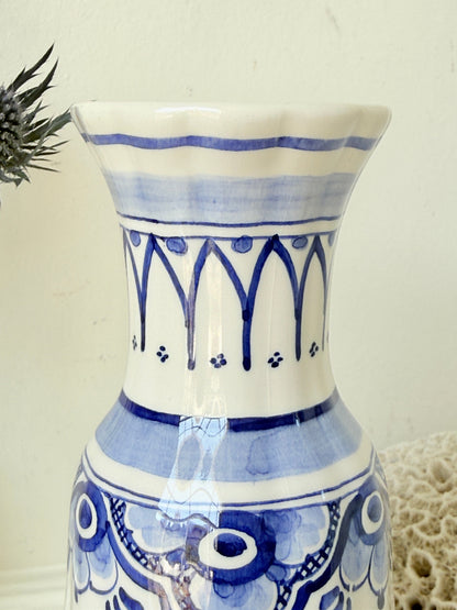 Vintage Delft style blue and white pottery vase with hand painted floral decoration, photographed on a white surface