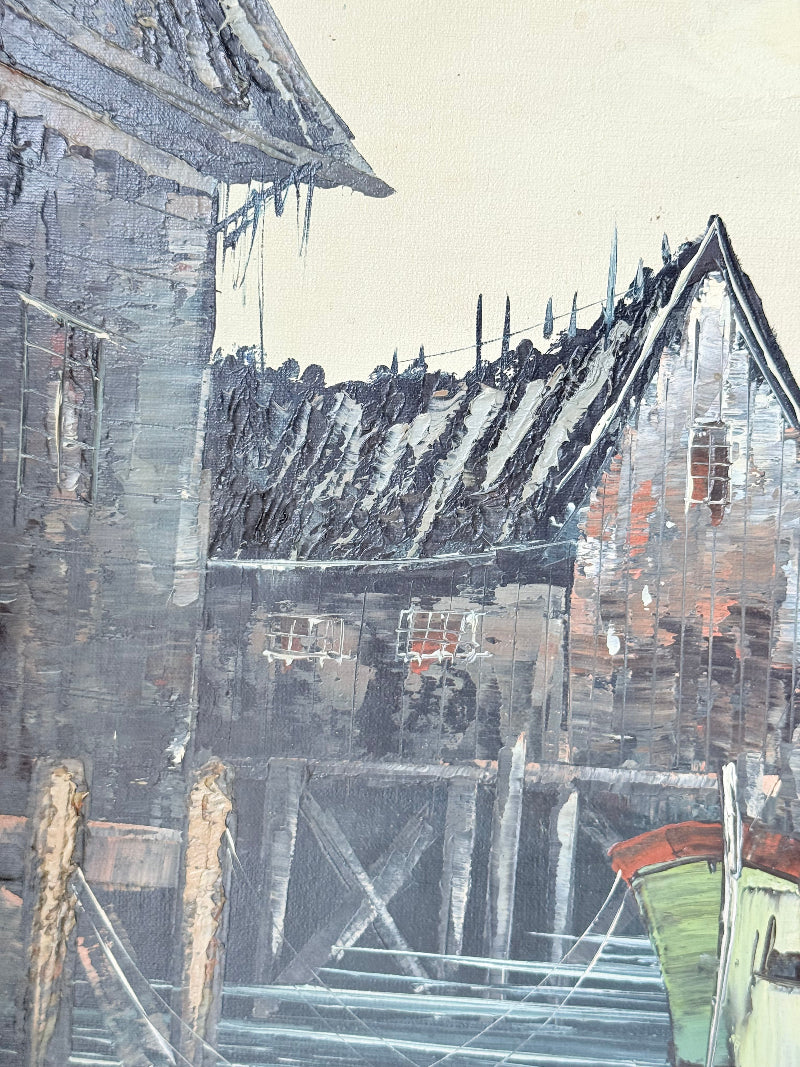 Vintage harbour scene oil painting of fishing boat and wharf buildings in gilt frame, textured brushwork, on white surface.