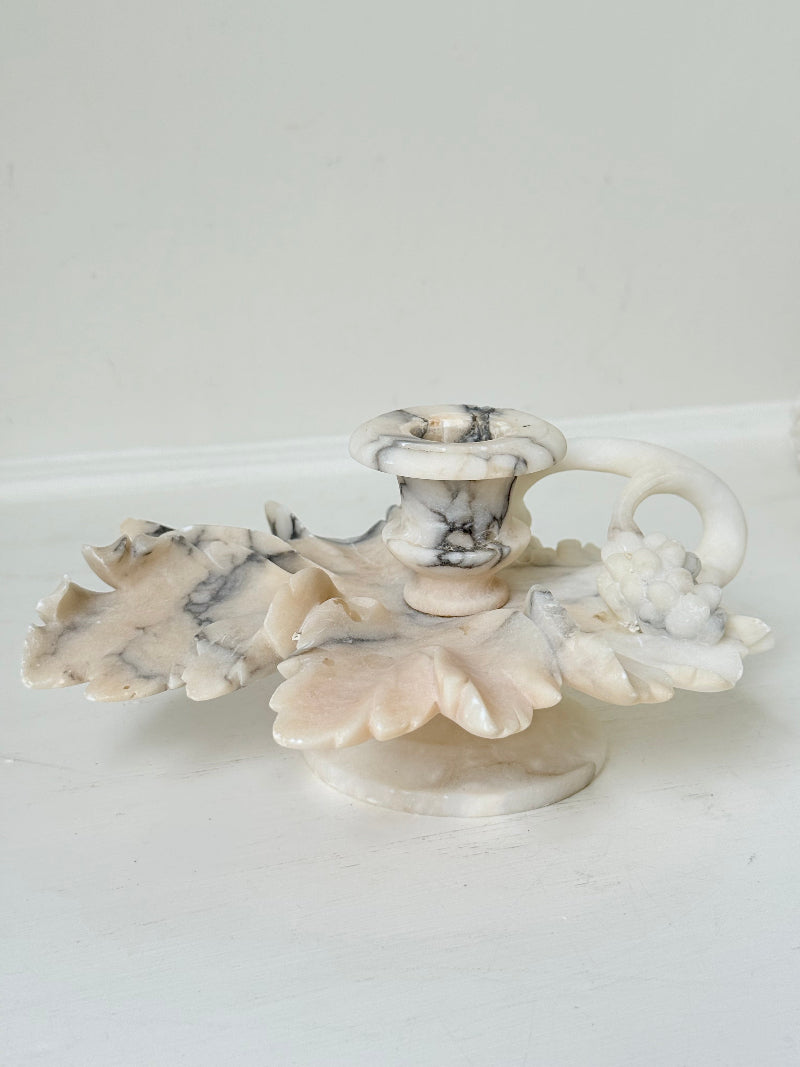Antique alabaster marble floral candleholder with carved leaves and flowers, photographed on a white surface.