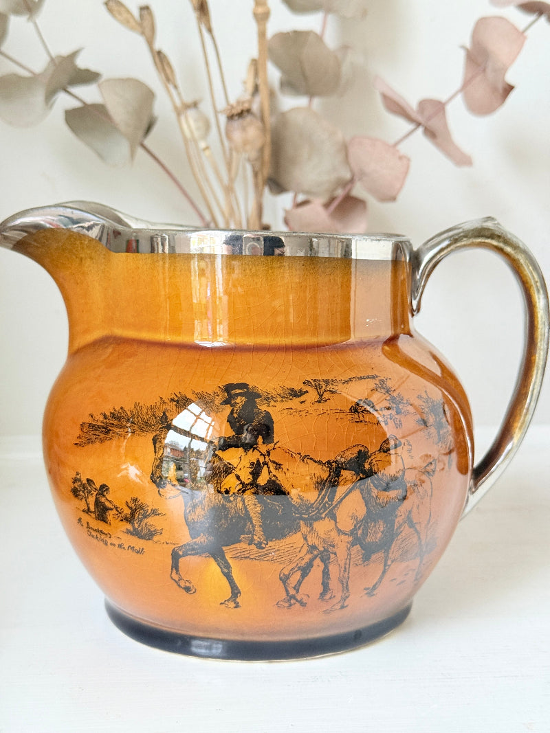 Pair of vintage Ridgways Coaching Days and Coaching Ways treacle jugs in amber brown glaze photographed on a white surface
