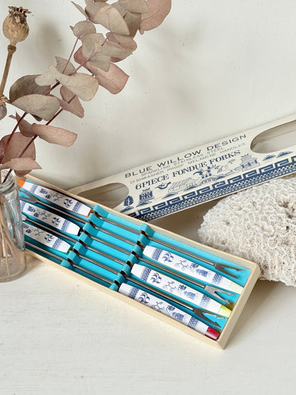 Set of 6 vintage Blue Willow fondue forks with coloured ends in original box, photographed on a white surface