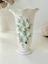 White Chessell Pottery studio vase with rippled rim and raised aqua floral decoration photographed on a white surface