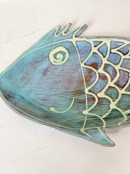 Barbados studio pottery fish platter in turquoise and sea green glaze photographed on a white surface