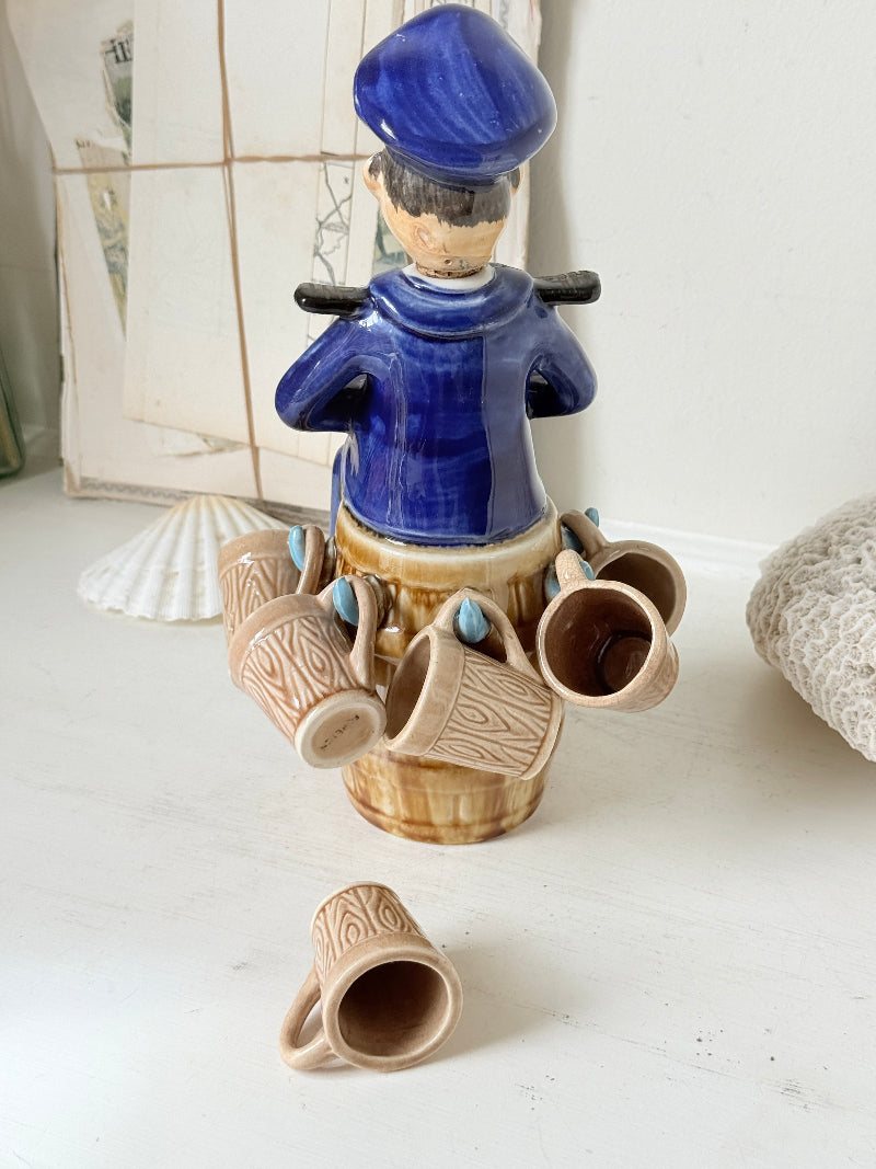 Vintage figural ceramic decanter set with captain, navy blue uniform, barrel base and 6 matching barrel shot cups