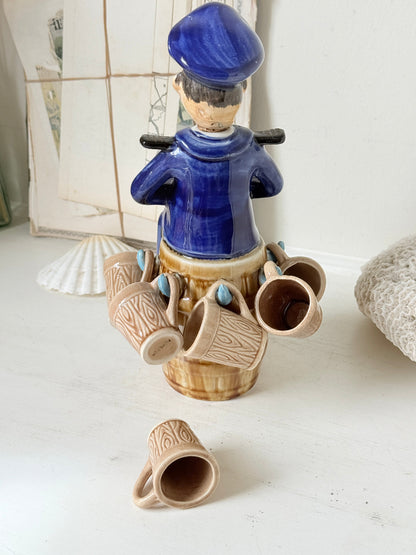 Vintage figural ceramic decanter set with captain, navy blue uniform, barrel base and 6 matching barrel shot cups