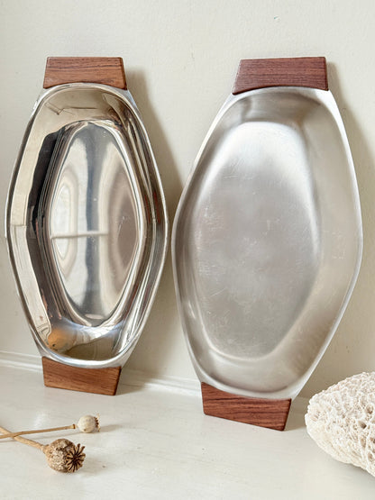 Pair of mid century stainless steel and teak crudites dishes photographed on a white surface