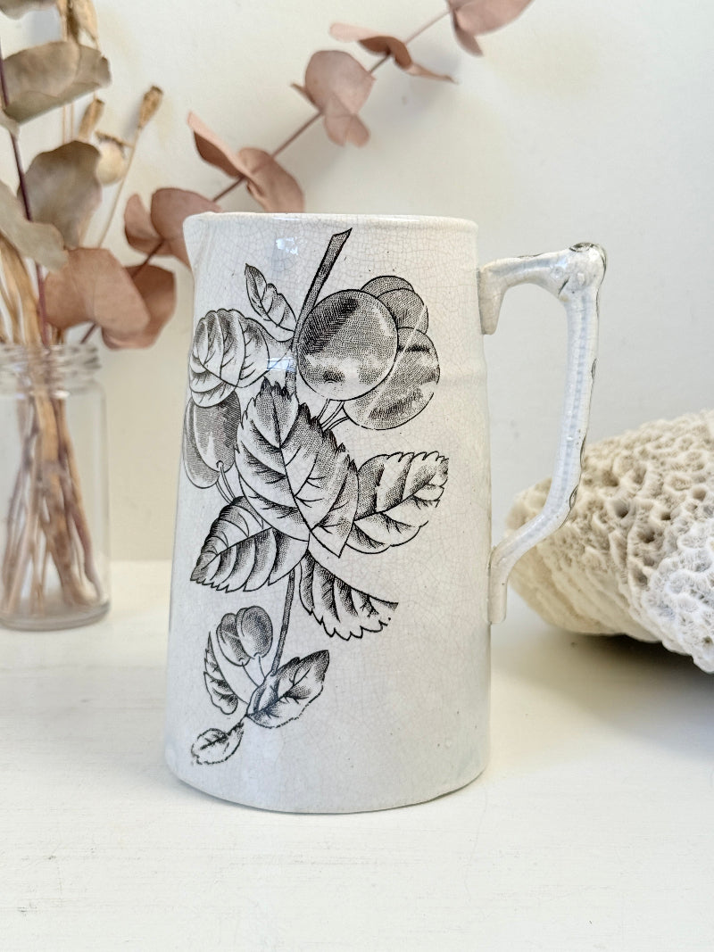 Antique English transferware jug with black fruit and leaf design, photographed on a white surface
