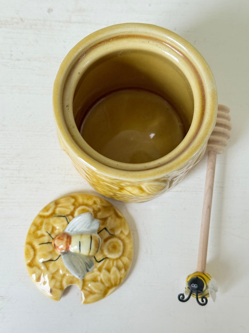 Secla pottery honey jar with lid, bee motif, and wooden honey spoon, made in Portugal, photographed on a white surface