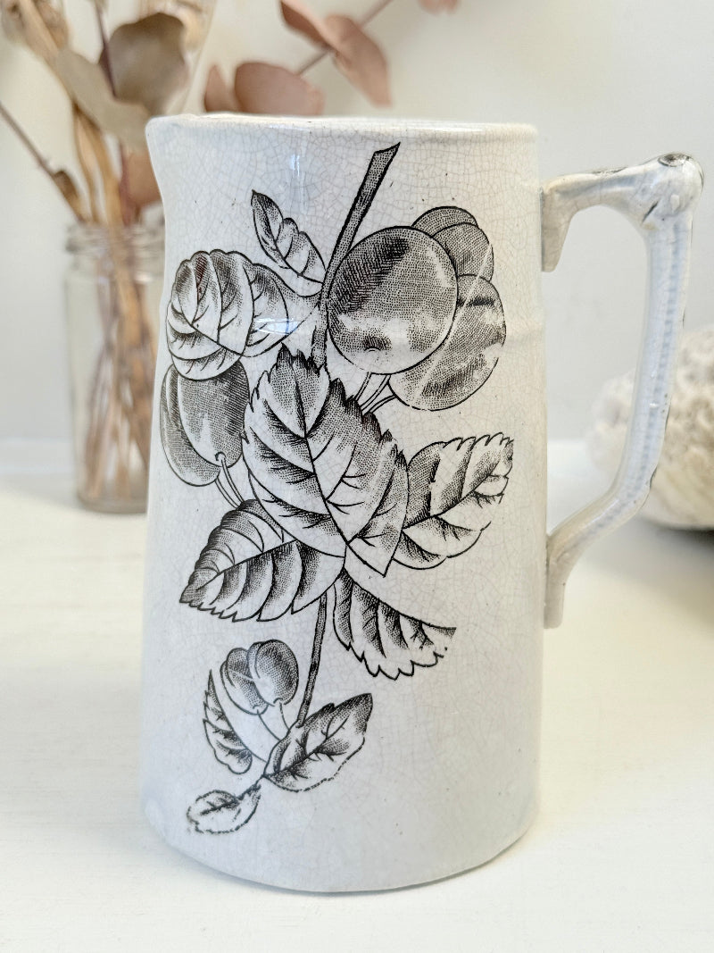 Antique English transferware jug with black fruit and leaf design, photographed on a white surface