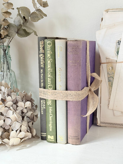 Bundle of vintage books with a heather purple cloth cover over green and cream spines tied with natural twine