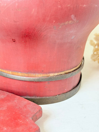 Vintage red painted wooden basket with upright handle and gold painted detail photographed on a white surface