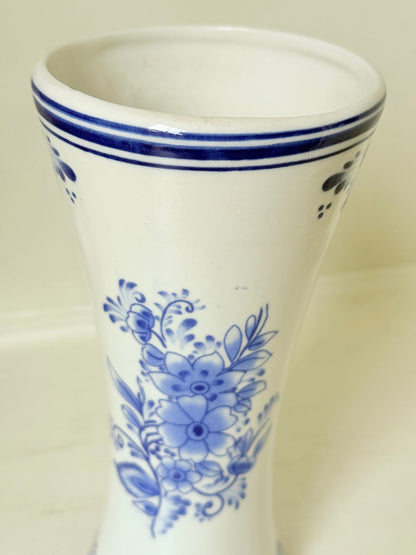 Blue and white Delft hand painted ceramic vase with windmill and floral decoration, photographed on white surface.