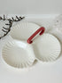 Poole Pottery double scallop hors d’oeuvre dish in white glaze with red handle photographed on a white surface