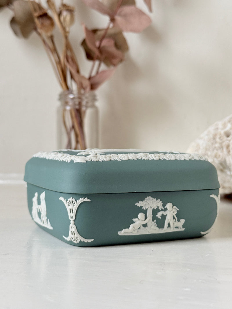 Vintage Wedgwood Jasperware teal green square lidded trinket box, decorated with white neoclassical figures and florets, styled with dried stems.