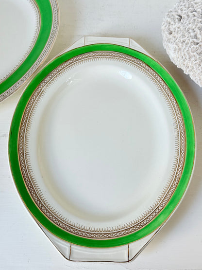 Pair of vintage oval serving platters with bright green Art Deco style border photographed on a white surface