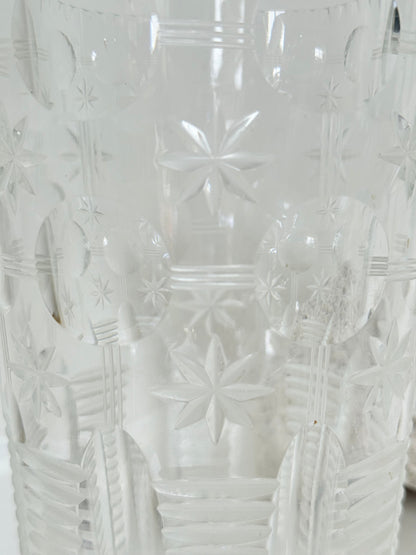 Vintage Stuart crystal cut glass vase with floral and star design, photographed on a white surface.