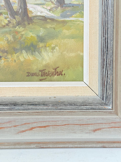 Close-up of a framed landscape painting showing a grassy field with trees and a signature reading Denis Thatcher.