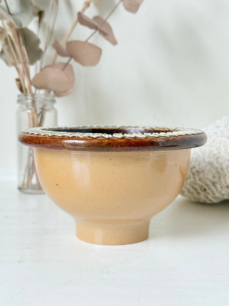 Antique Doulton Lambeth drainer bowl dated 1881 with blue floral interior glaze and drainage holes, photographed on a white surface