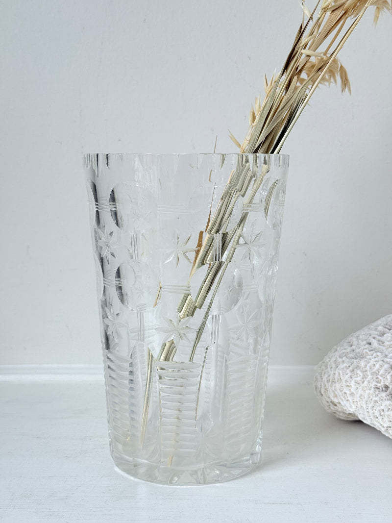 Vintage Stuart crystal cut glass vase with floral and star design, photographed on a white surface.