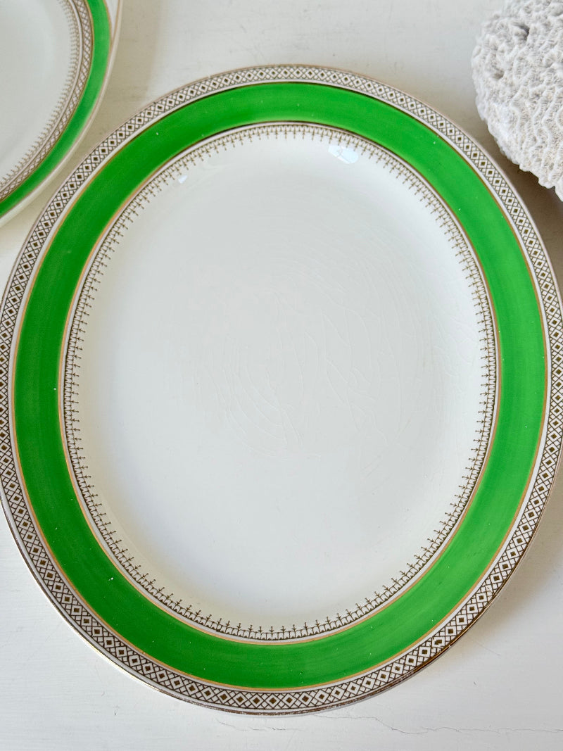 Pair of vintage oval serving platters with bright green Art Deco style border photographed on a white surface
