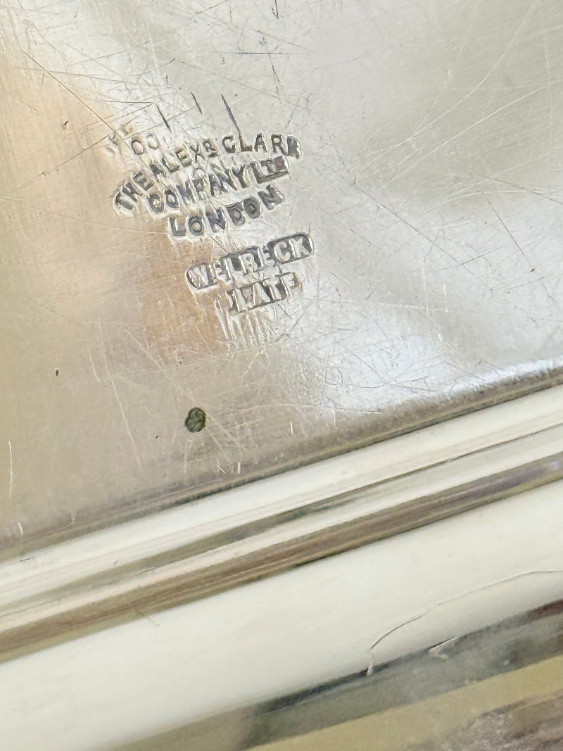 Close-up of a silver-toned metal surface with engraved maker&