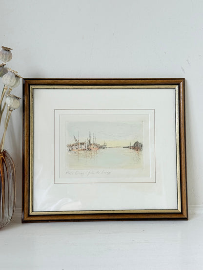 Framed vintage print of Poole Quay harbour scene in muted tones, under glass with gilt and wood-effect frame, on white surface.