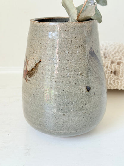 Hand thrown studio pottery vase with ash glaze and brushstroke motif, photographed on white surface