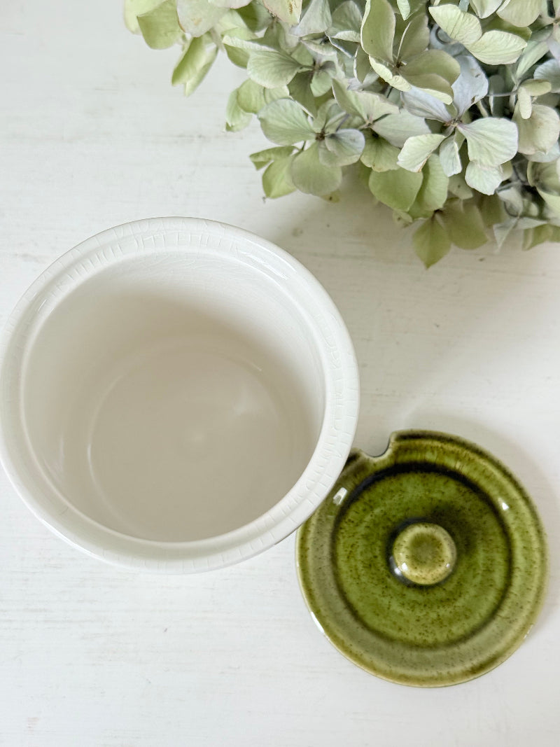vintage Holkham pottery condiment pot with green lid and illustrated figures photographed on white surface