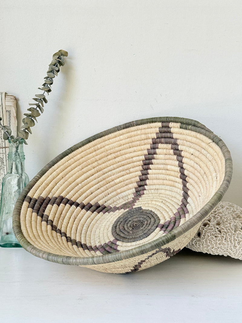 Large hand woven coiled basket with three point star pattern, natural fibre and dark geometric detail for wall or table styling