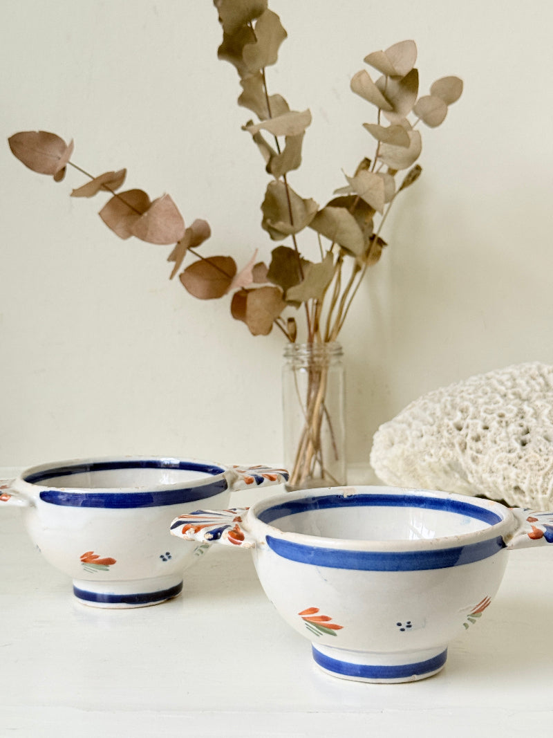 Pair of vintage French Quimper olive bowls with Breton figure and fan handles, photographed on a white surface