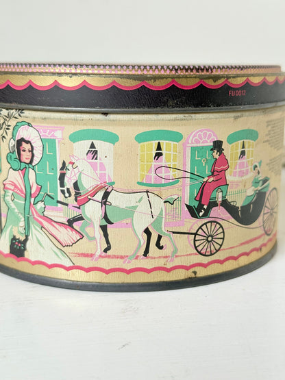 Vintage Quality Street tin from 1986 with colourful illustrated street scenes and pastel design, photographed on a white surface.