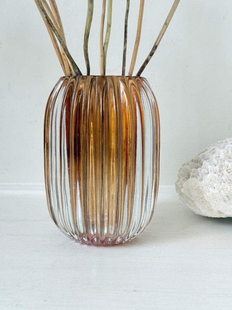 Vintage ribbed amber brown glass vase photographed on a white surface