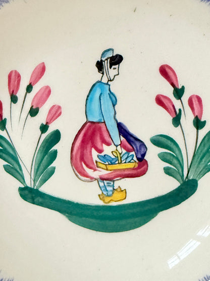 French Quimper faience handled wall dish with Petit Breton figure and blue rim, photographed on a white surface