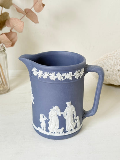 Vintage Wedgwood Portland blue Jasperware jug decorated with white neoclassical figures and a grapevine border, styled with dried stems.