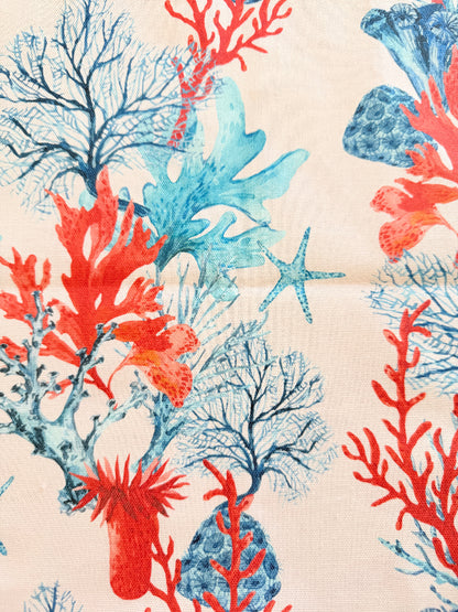 The Blue Loft coral reef cotton tea towels in turquoise and pale pink with coastal marine pattern photographed on a stone surface.