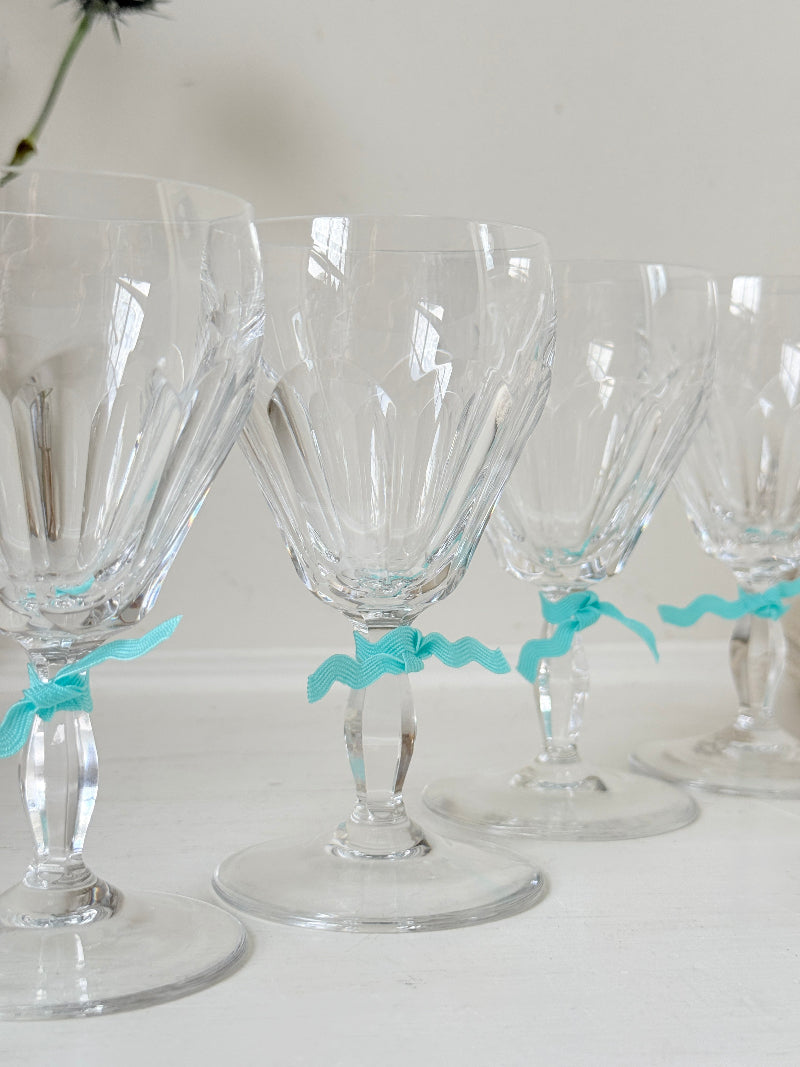 Set of four vintage cut crystal aperitif glasses with faceted bowls, photographed on a white surface