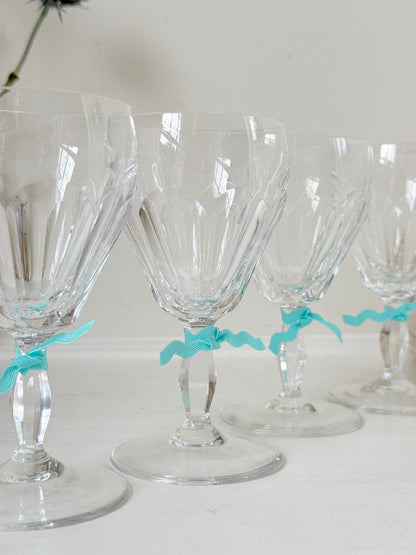 Set of four vintage cut crystal aperitif glasses with faceted bowls, photographed on a white surface