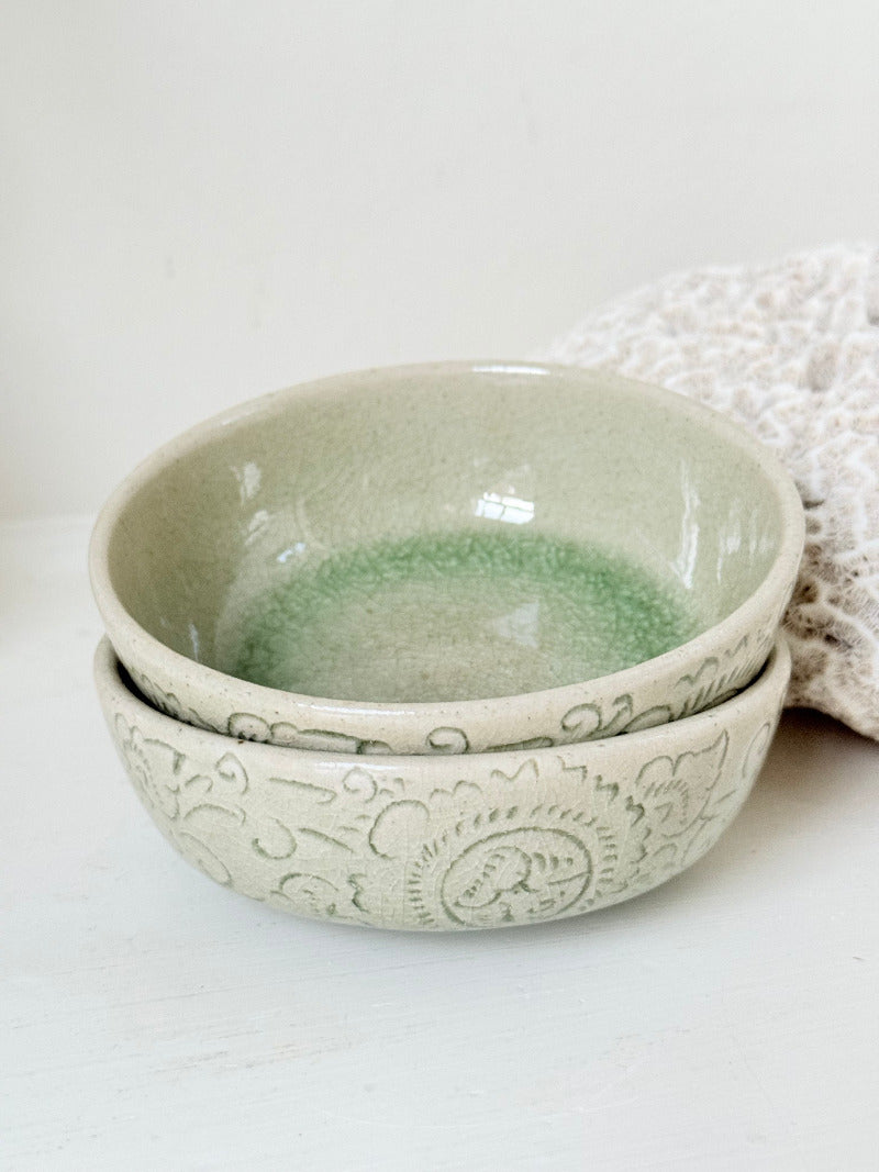 Pair of sage green Thai celadon olive bowls with crackled glaze, photographed on white surface
