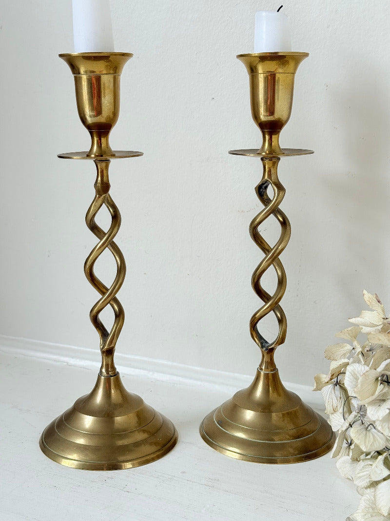 pair of brass candlesticks with spiral twist stems photographed on white surface