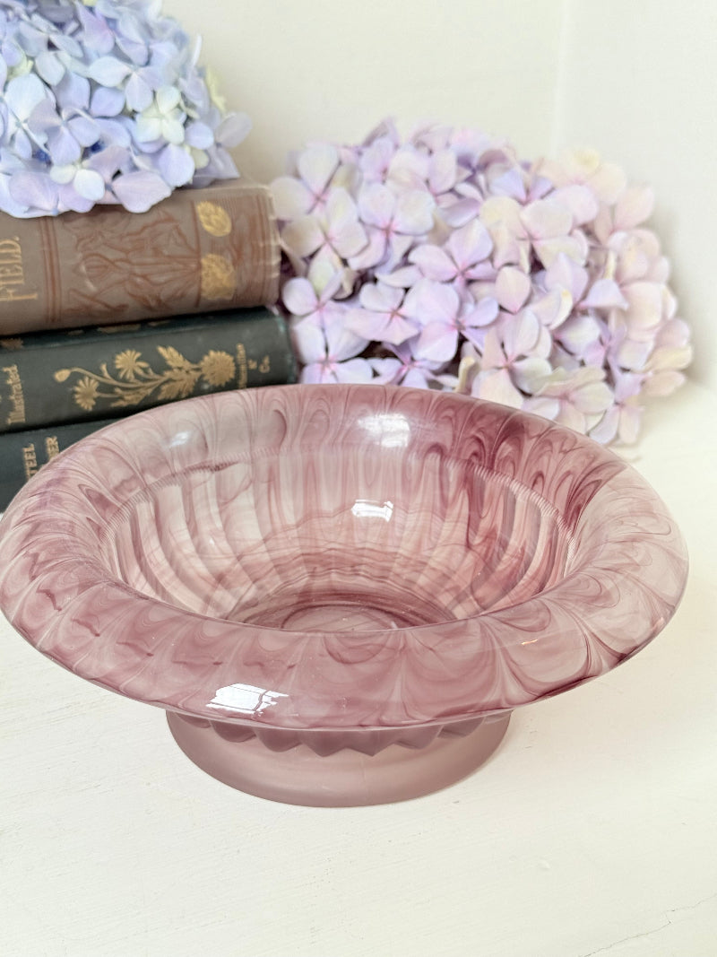 Davidson Cloud Glass bowl in amethyst with swirl pattern and footed base, styled with books and hydrangeas