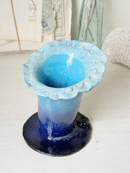 Handmade studio pottery trumpet vase in ombre blue with a frilled rim, photographed on a white surface