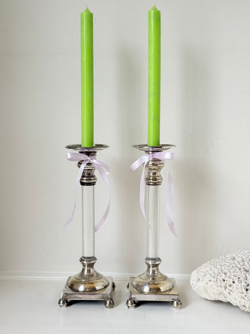 Pair of Hollywood Regency silver plate and Perspex Lucite candlesticks on bun feet with green taper candles