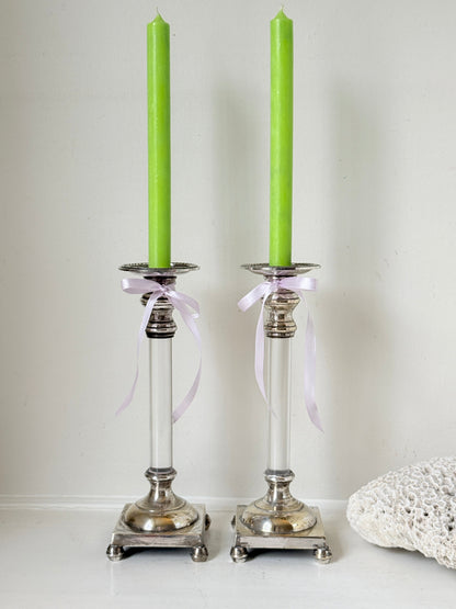 Pair of Hollywood Regency silver plate and Perspex Lucite candlesticks on bun feet with green taper candles