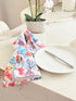 Coral reef print cotton tea towel in crisp white with colourful coral and tropical fish motifs, photographed indoors with a white plate