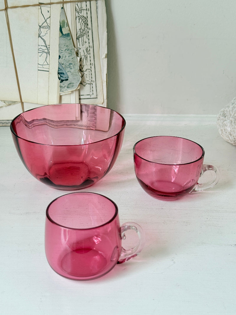 Trio of antique cranberry glass with sugar bowl, teacup, coffee can, clear glass handles and deep pink glass