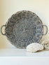 Large vintage woven basket with handles, photographed on a white surface
