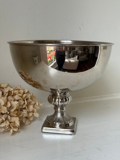 Vintage polished metal champagne bowl with pedestal base, photographed on a white surface