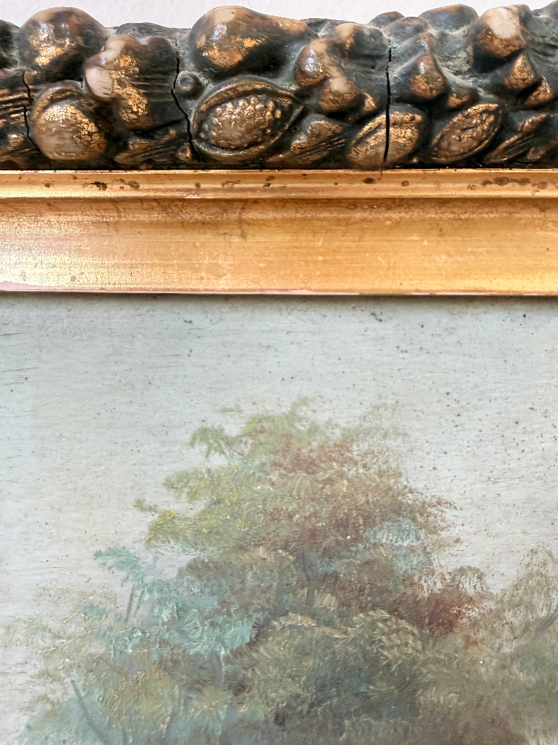 Close-up of an antique framed painting showing a textured gold and dark brown carved frame above a muted landscape painting with trees.