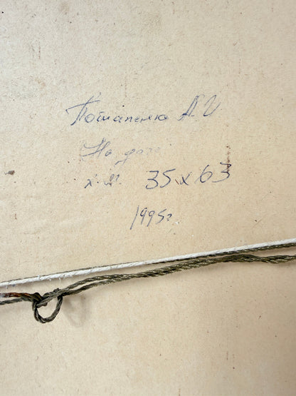 Close-up of a beige paper or canvas surface with handwritten blue ink text and a thin dark cord or string running horizontally across the lower portion.